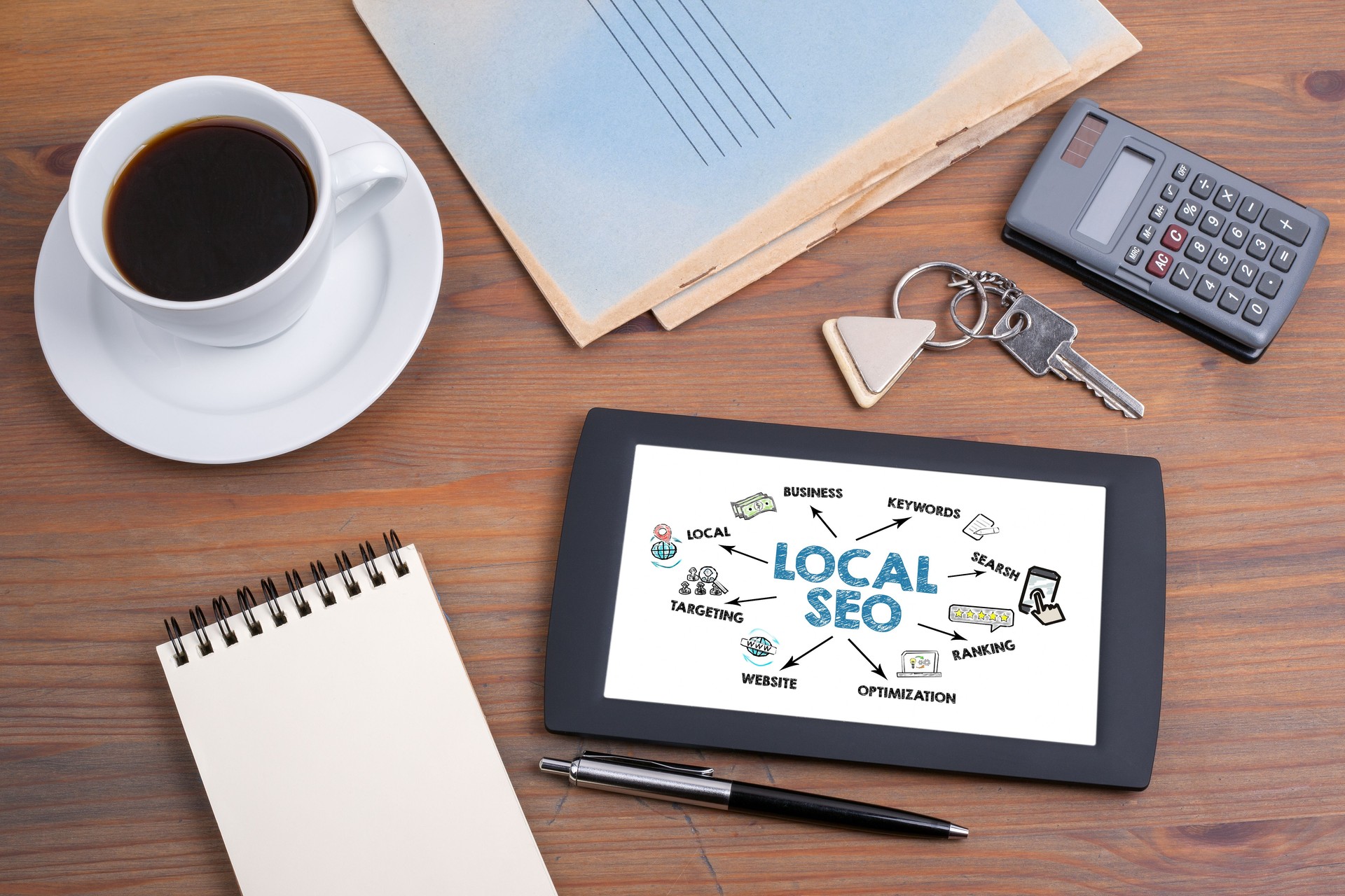 Local Seo Concept. Illustration with icons, arrows and keywords. Tablet device on a wooden table