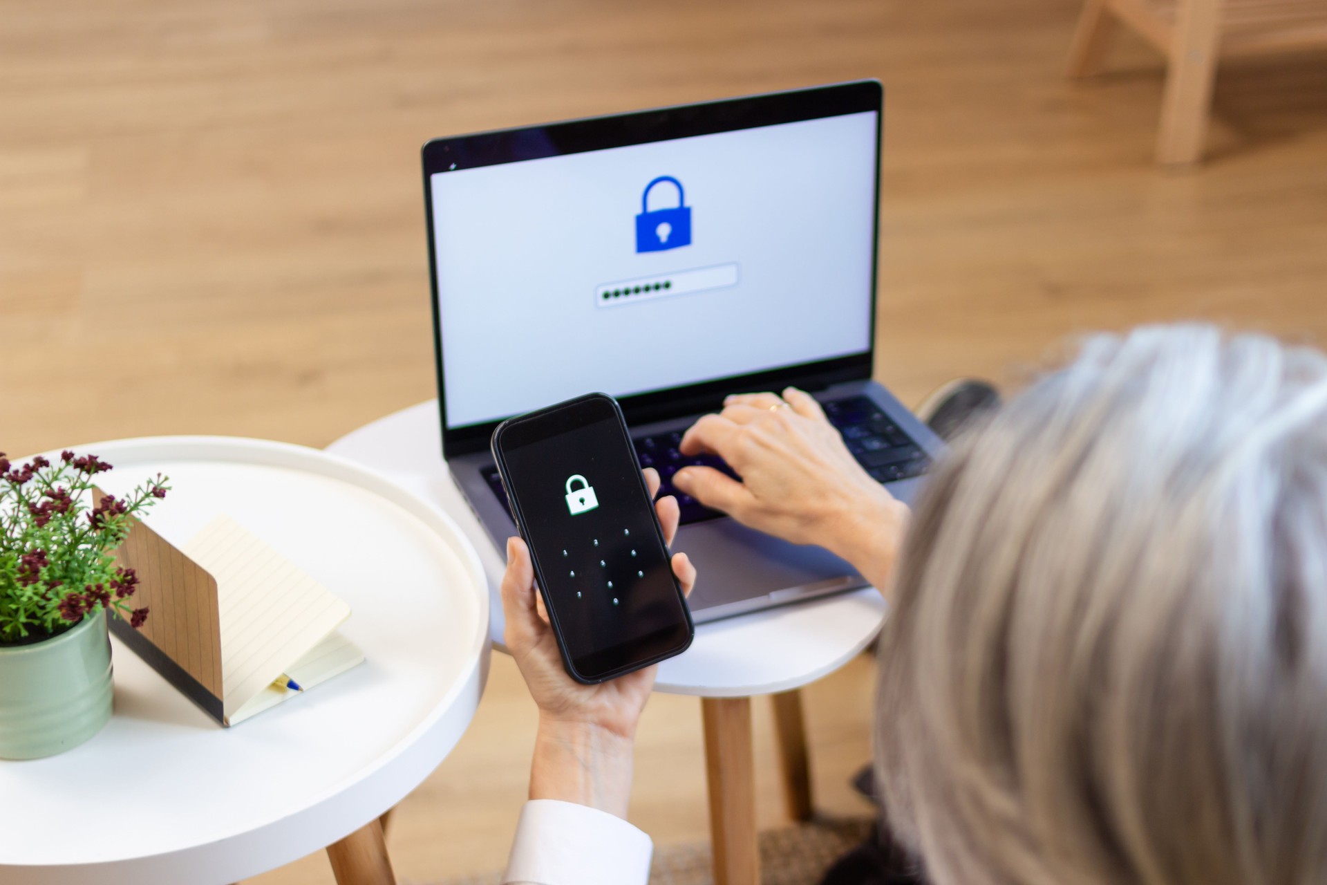 Senior woman using laptop and smartphone for multi-factor authentication