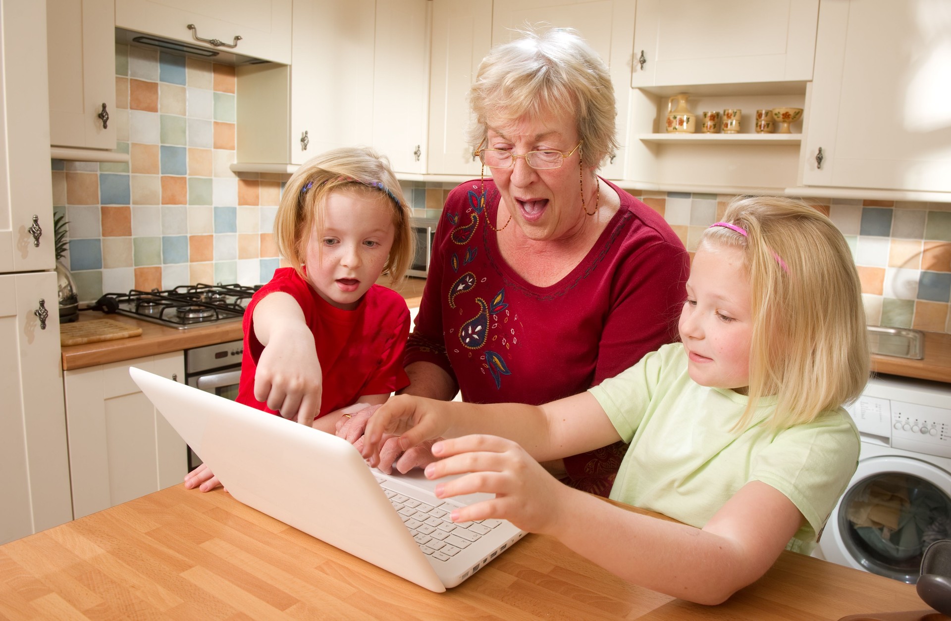 Two Girls and Their Grandmother Looking at a Laptop